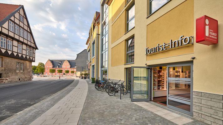 Eingang der Tourist-Info in modernem Gebäude, im Hintergrund Fachwerkhäuser