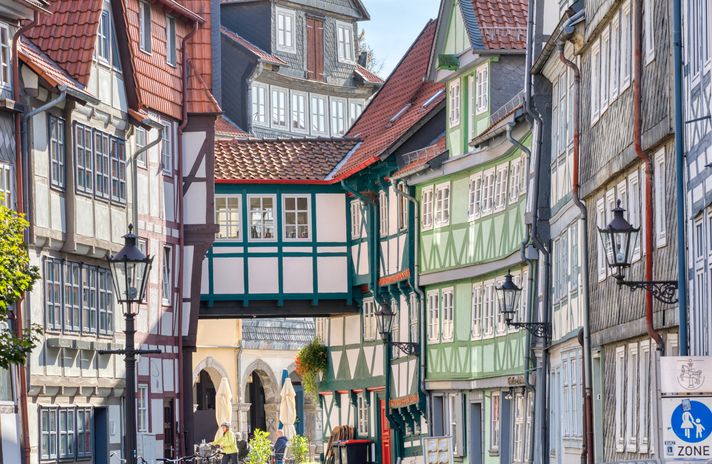 Enge Gasse in Wolfenbüttel mit bunten Fachwerkhäusern, historischem Durchgang und Laternen.